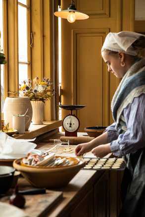 Kvinde bager på Frilandsmuseet